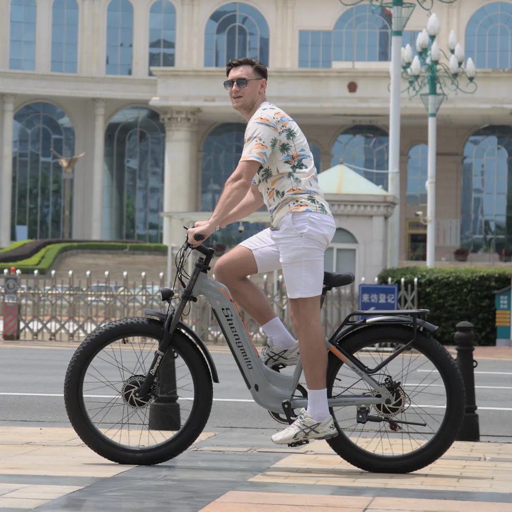 Rider on the Shengmilo MX06PRO Electric Bike cruising along a city road, emphasizing the bike’s versatility, comfortable ride, and modern features suited for daily commuting.