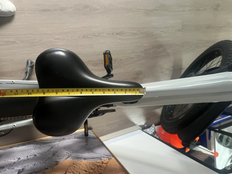 Measuring the length of the Shengmilo S600 e-bike saddle from front to back to find the midpoint